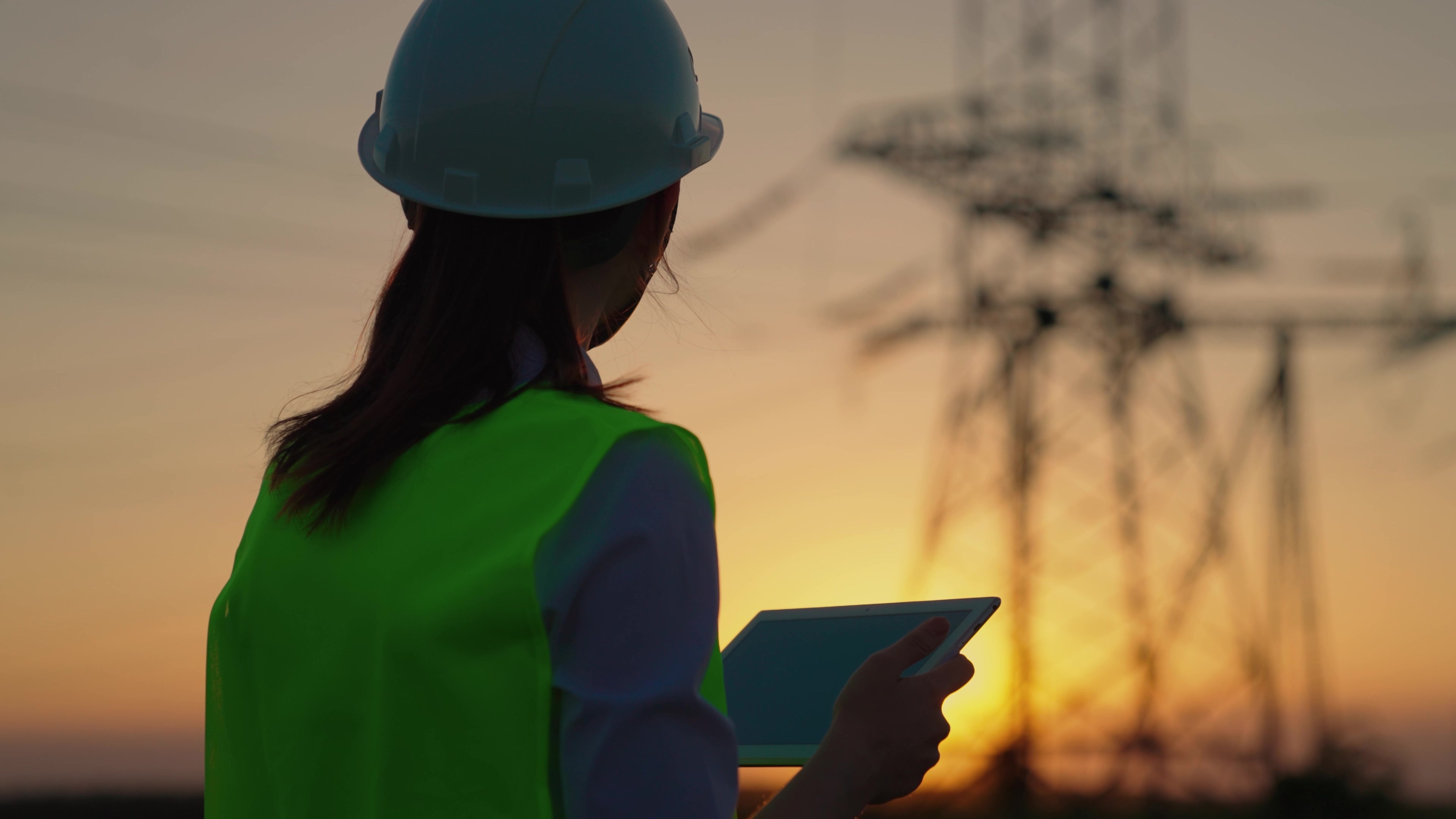 An engineer examining a pylon in the distance